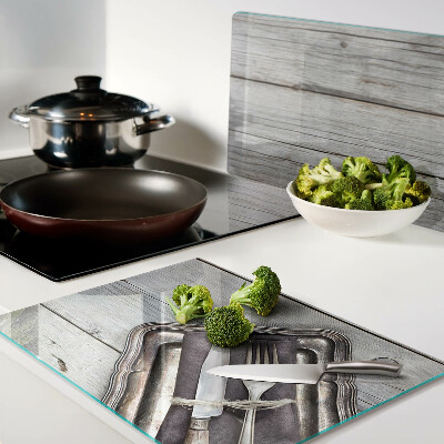 Chopping board glass Rustic cutlery on a wooden background