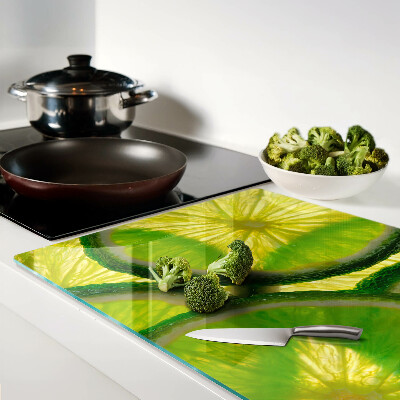 Glass kitchen board Lime slices on a green background