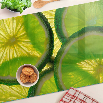 Glass kitchen board Lime slices on a green background