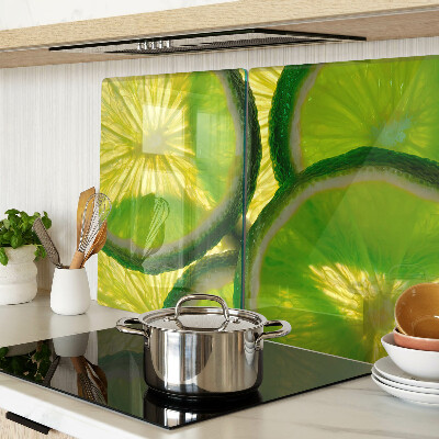 Glass kitchen board Lime slices on a green background