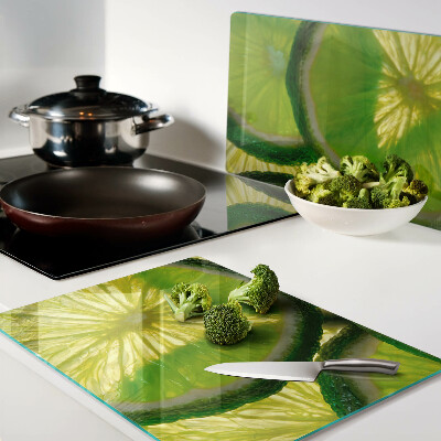 Glass kitchen board Lime slices on a green background