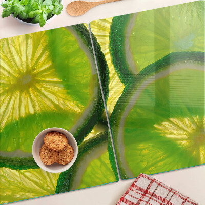 Glass kitchen board Lime slices on a green background