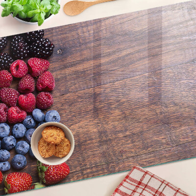 Chopping board Forest fruits on a wooden background