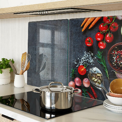 Glass cutting board Vegetables and spices on a dark background