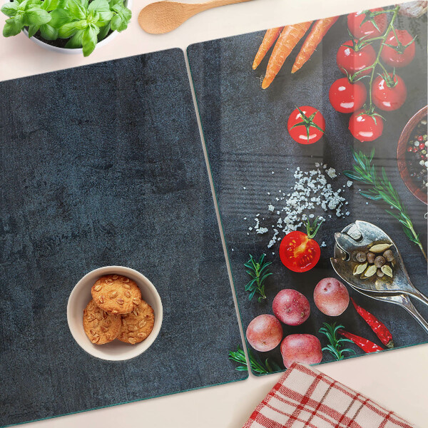 Glass cutting board Vegetables and spices on a dark background