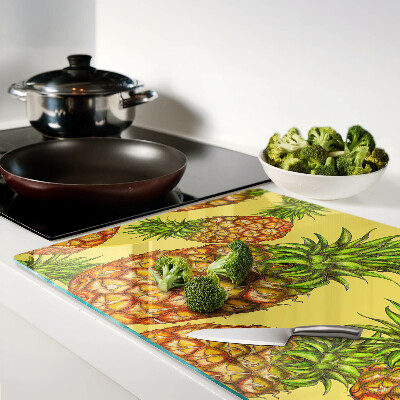 Glass kitchen board Pineapples on a yellow background