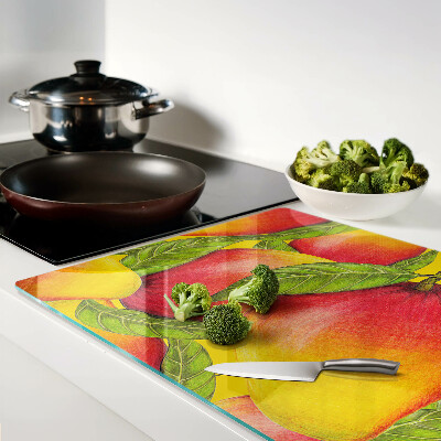 Chopping board glass Peppers on a background of green leaves