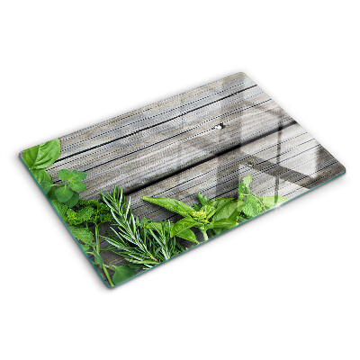 Chopping board glass Green herbs on a wooden background