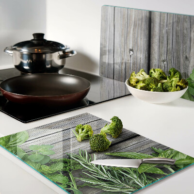 Chopping board glass Green herbs on a wooden background