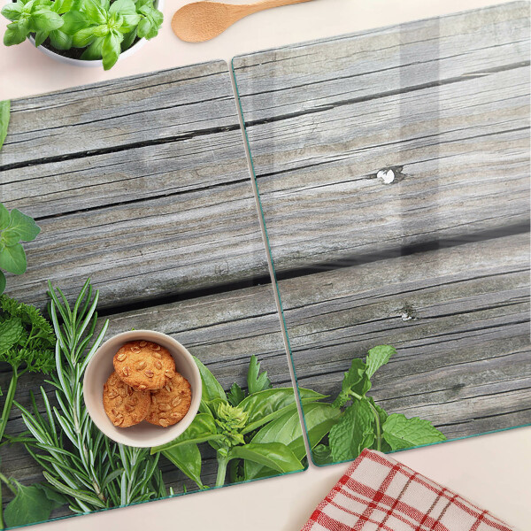 Chopping board glass Green herbs on a wooden background