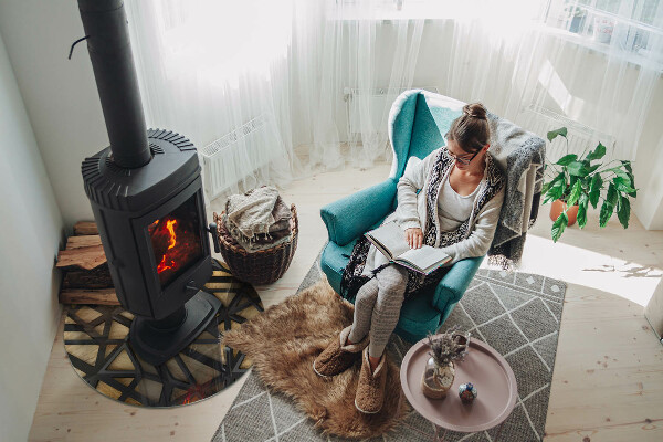 Round glass hearth for log burner Modern shapes with a wooden accent