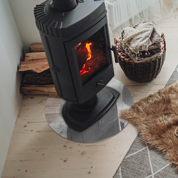 Round glass hearth for log burner Concrete texture in a raw style