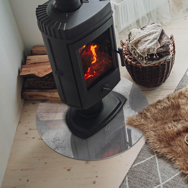 Round glass hearth for log burner Concrete texture in a raw style