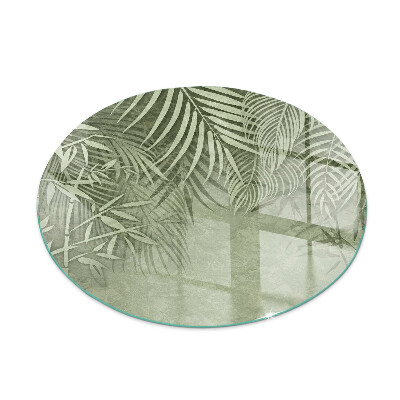 Round glass hearth Tropical leaves on the background