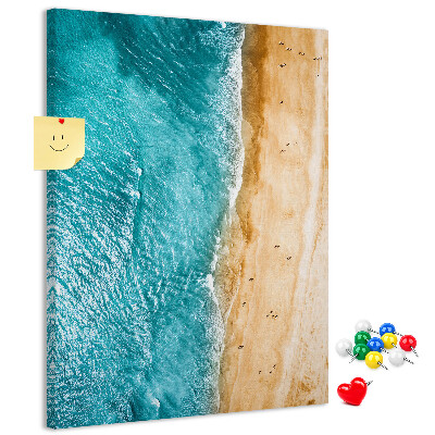 Memo cork board A beach with waves and people walking around