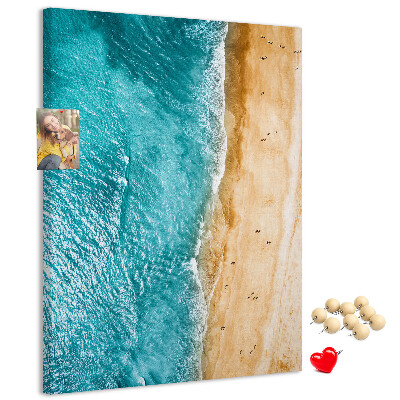 Memo cork board A beach with waves and people walking around