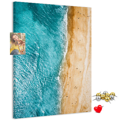 Memo cork board A beach with waves and people walking around