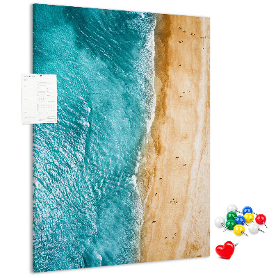 Memo cork board A beach with waves and people walking around