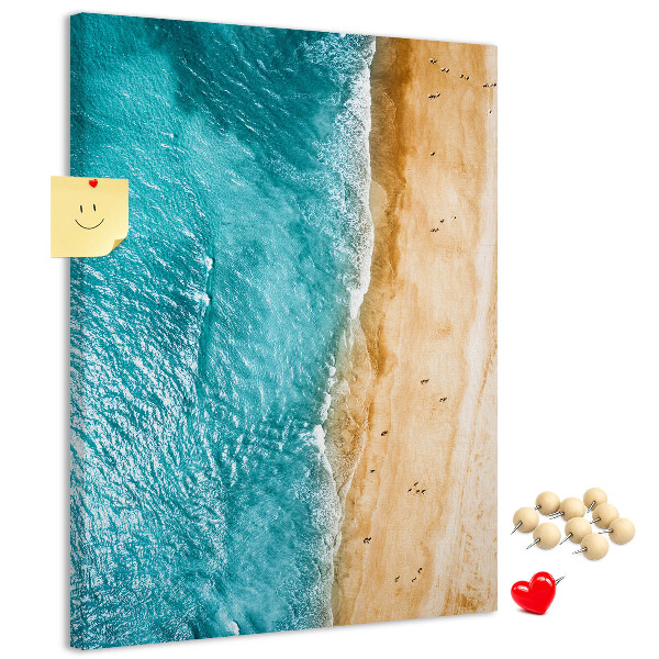 Memo cork board A beach with waves and people walking around