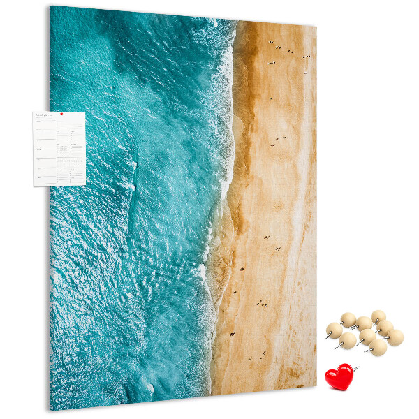 Memo cork board A beach with waves and people walking around