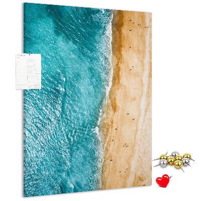 Memo cork board A beach with waves and people walking around