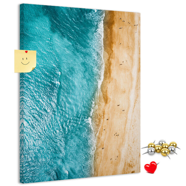 Memo cork board A beach with waves and people walking around