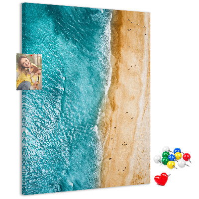 Memo cork board A beach with waves and people walking around
