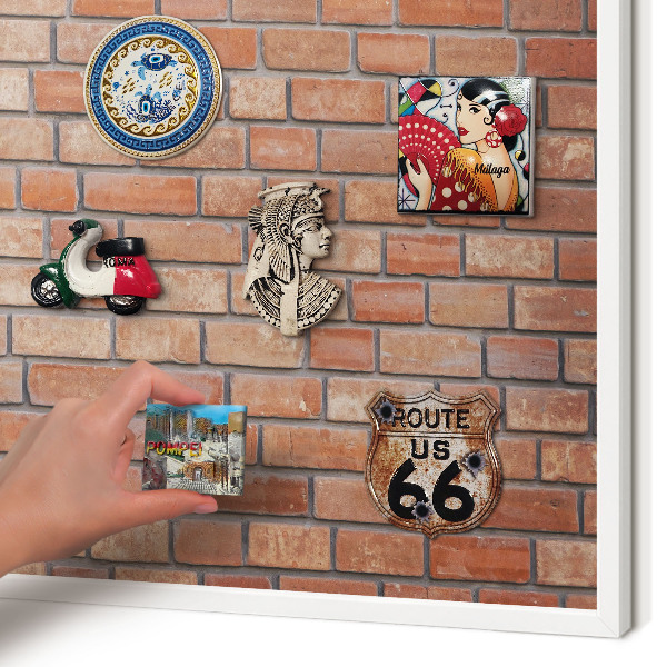 Magnetic board for travel magnets in a white frame Brick wall