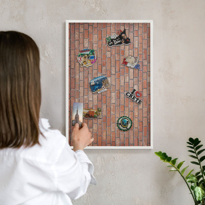 Magnetic board for travel magnets in a white frame Brick wall