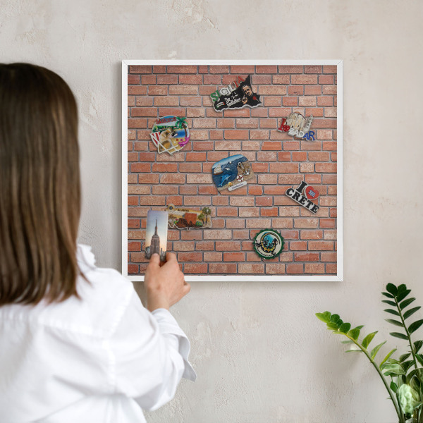 Magnetic board for travel magnets in a white frame Brick wall