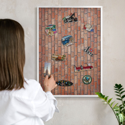 Magnetic board for travel magnets in a white frame Brick wall