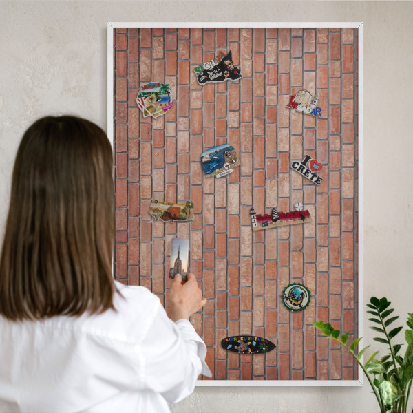 Magnetic board for travel magnets in a white frame Brick wall