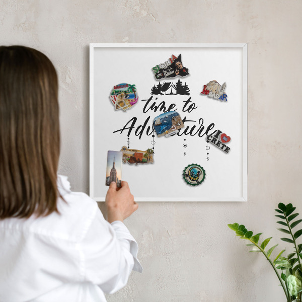 Magnetic board for travel magnets in a white frame Adventure awaits