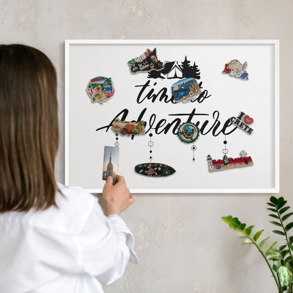 Magnetic board for travel magnets in a white frame Adventure awaits