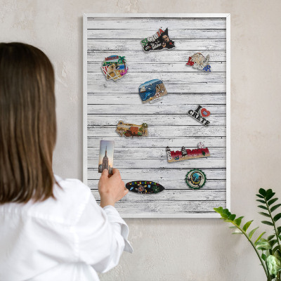 Magnetic board for travel magnets in a white frame Light wood