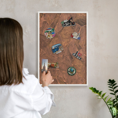Magnetic board for travel magnets in a white frame Stone structure