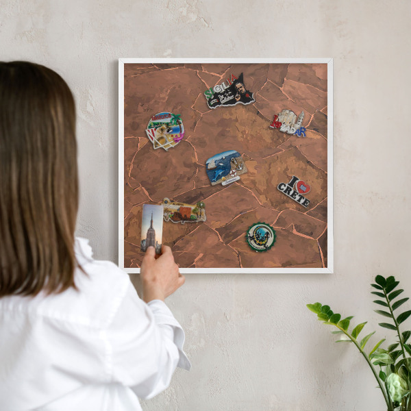 Magnetic board for travel magnets in a white frame Stone structure
