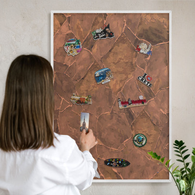 Magnetic board for travel magnets in a white frame Stone structure