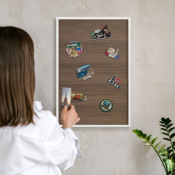 Magnetic board for travel magnets in a white frame Wooden background