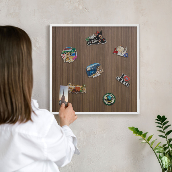 Magnetic board for travel magnets in a white frame Wooden background