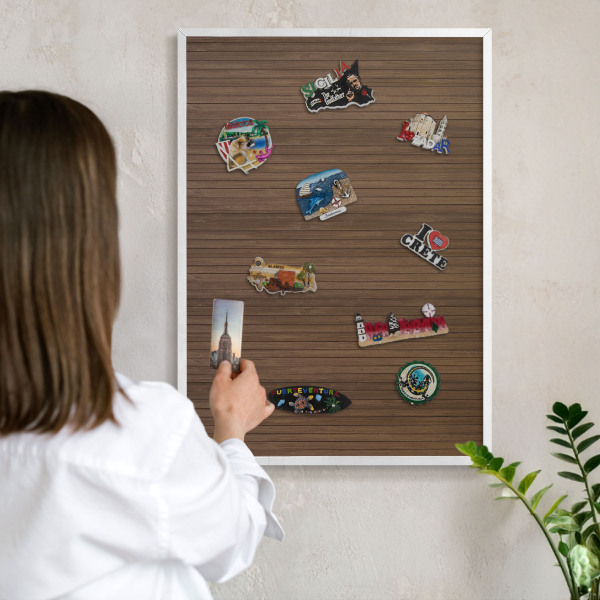 Magnetic board for travel magnets in a white frame Wooden background