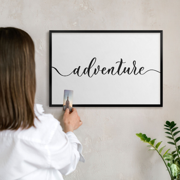 Vacation magnet board with a black frame Adventure written
