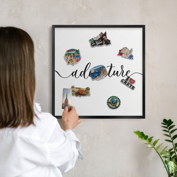 Vacation magnet board with a black frame Adventure written