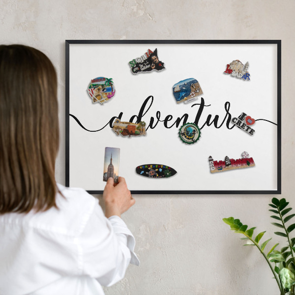Vacation magnet board with a black frame Adventure written