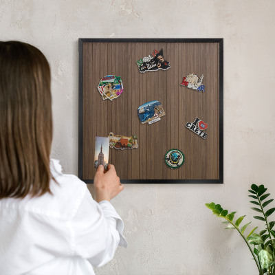 Metal wall board for magnets in a black frame Wooden background
