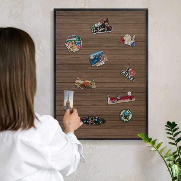 Metal wall board for magnets in a black frame Wooden background
