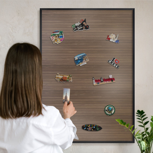 Metal wall board for magnets in a black frame Wooden background