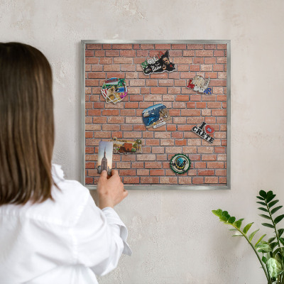 Souvenir magnet display board with a silver frame Brick wall