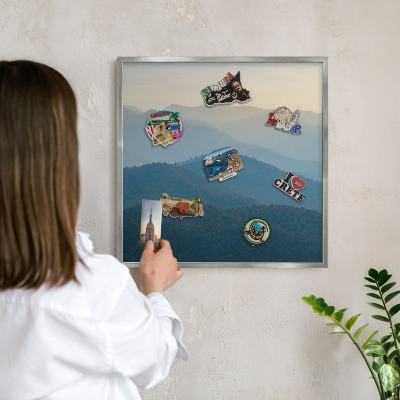 Souvenir magnet display board with a silver frame Mountain views