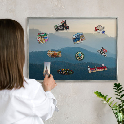 Souvenir magnet display board with a silver frame Mountain views